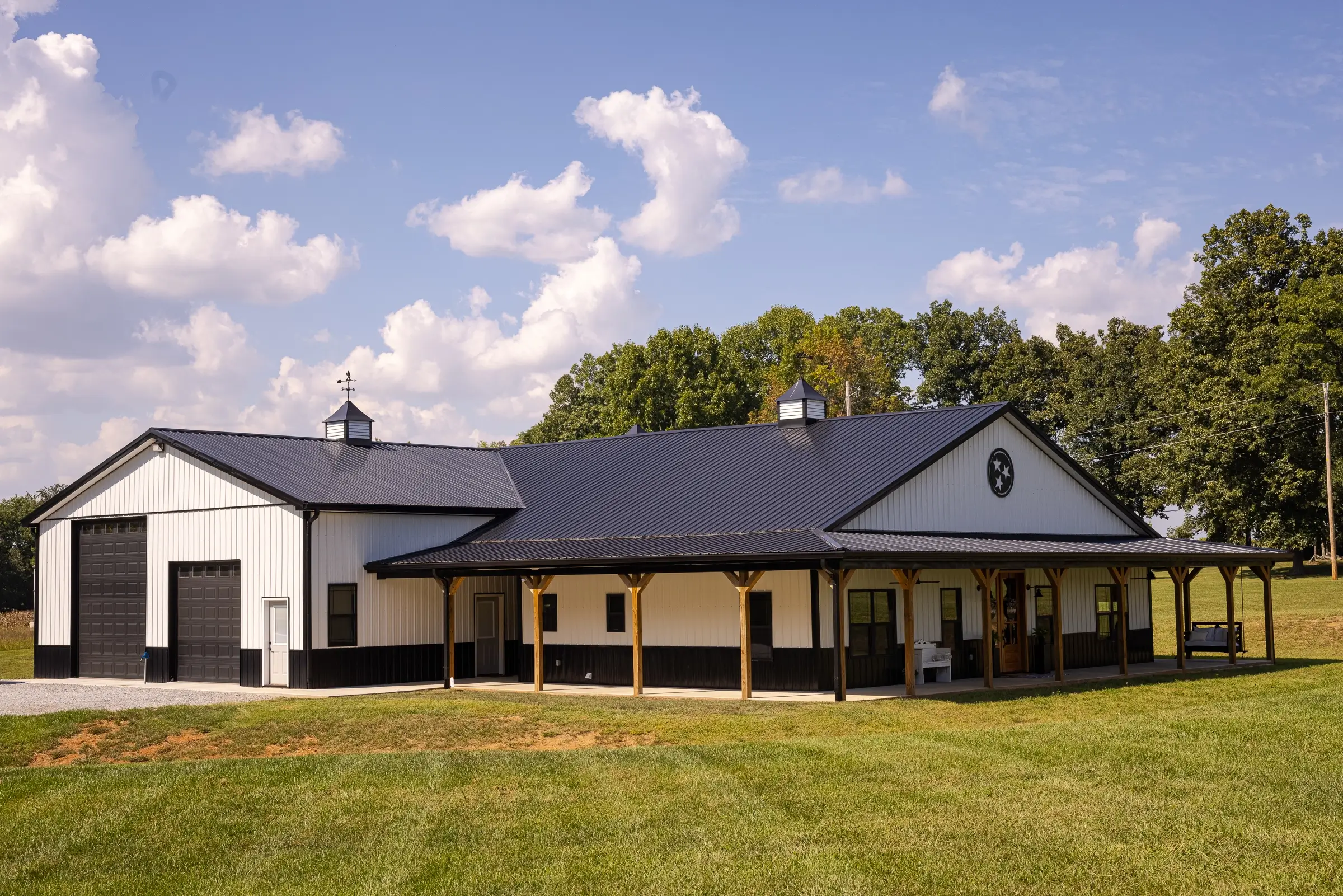 A barndominium on acreage in Texas with a blue sky and trees